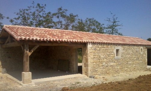 Construction d'un garage habillage pierre et pose d'une toiture traditionnelle .